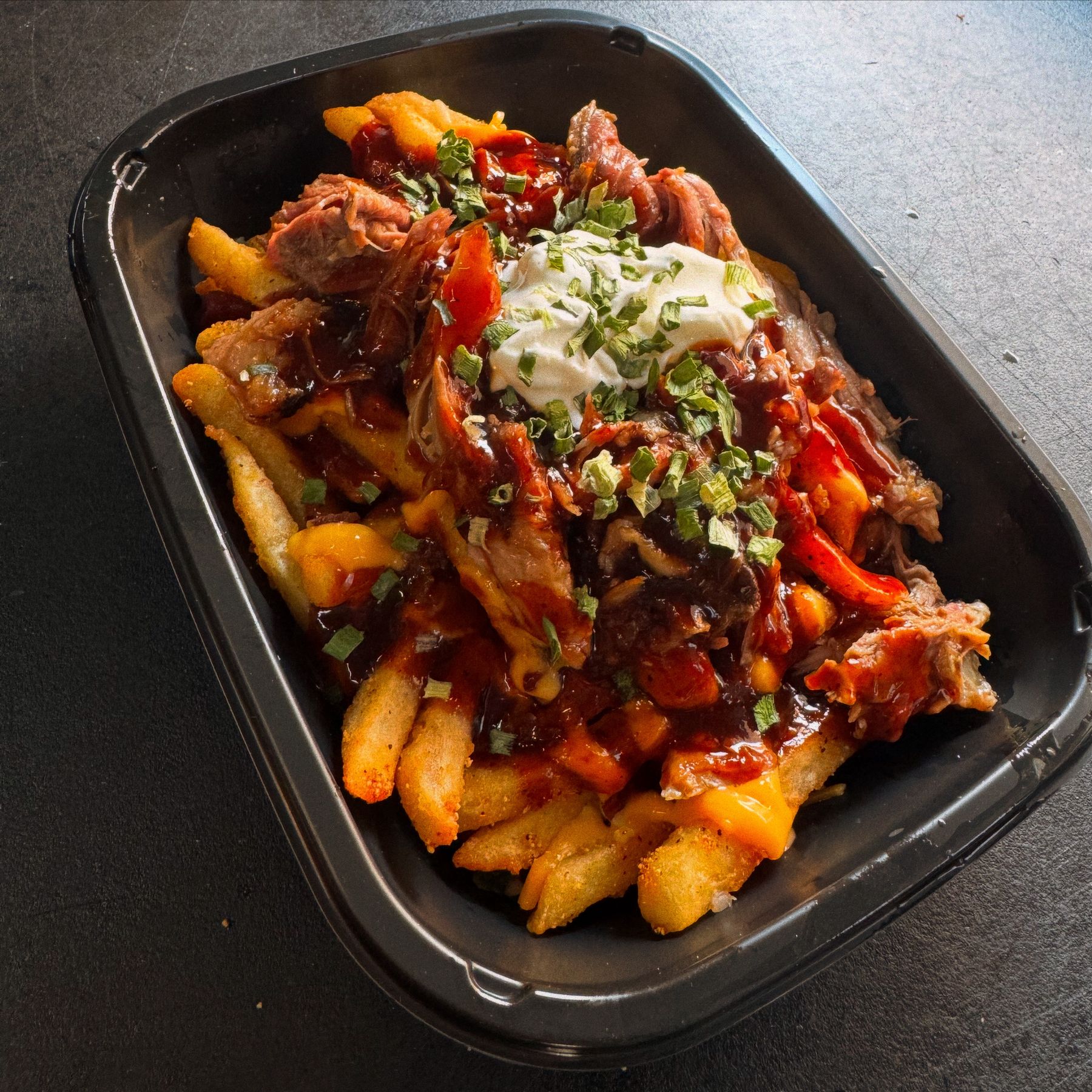 Smoked brisket sandwich with BBQ sauce and seasoned fries from Rolling Smokehouse food truck Hartford County CT